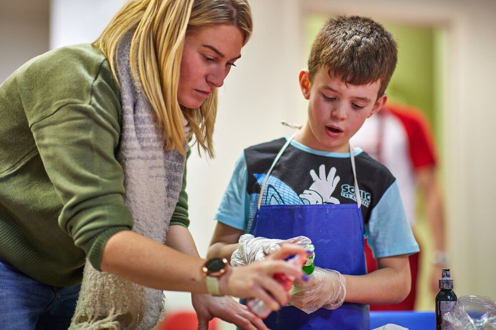 A woman teaching a boy about t-shirt making.