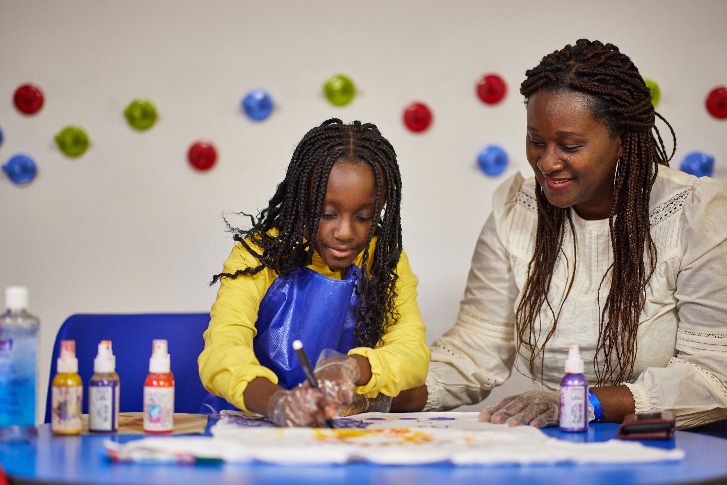 A mother and his child happily designing a t-shirt.