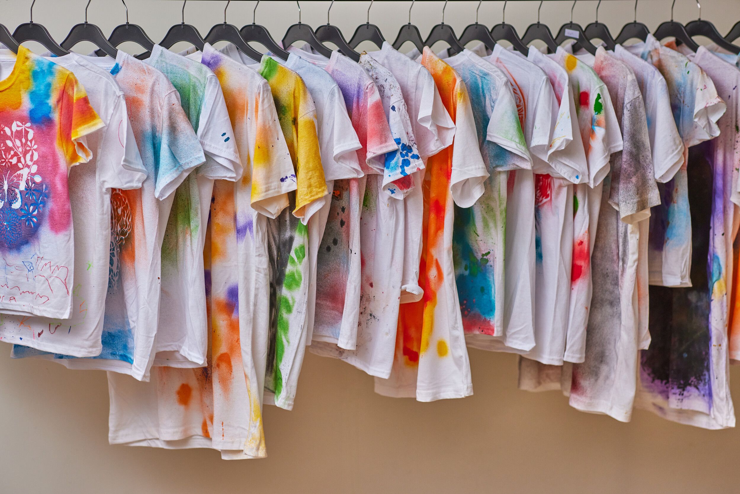 A bunch of t-shirts with different designs hanging in a clothesline.