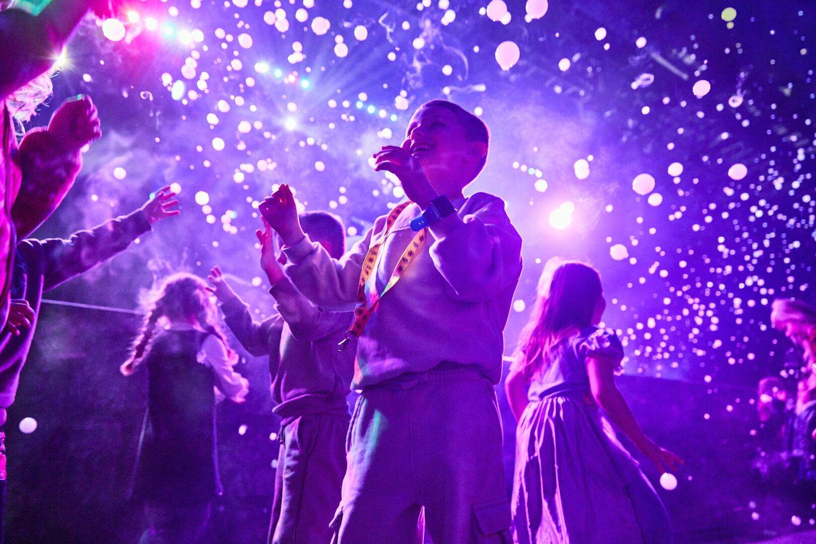 A low-angle shot of the audience during an Animals and Mythical Beasts show at Butlin's, as confetti falls down over them.