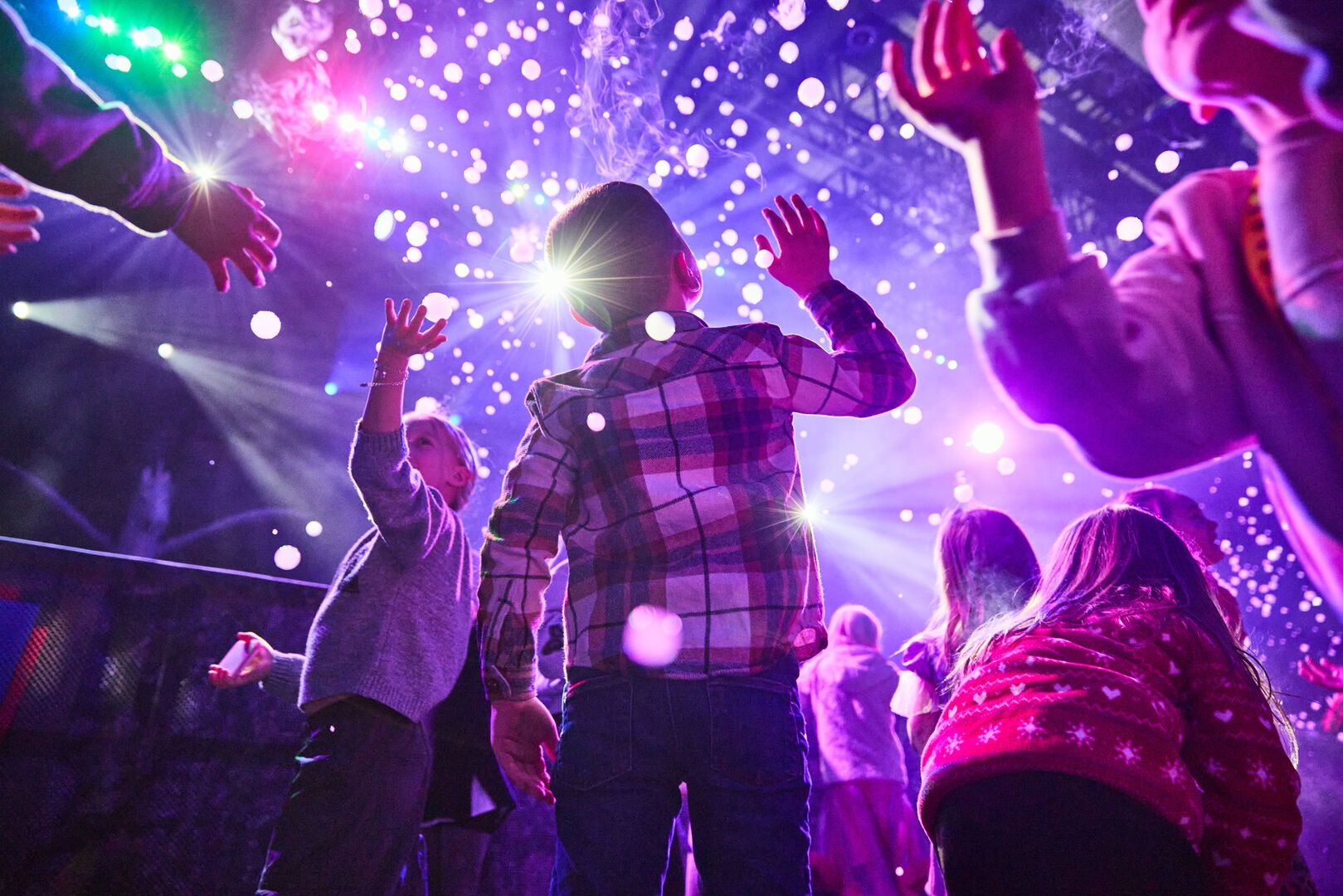 A low-angle shot of the audience during an Animals and Mythical Beasts show at Butlin's, as confetti falls down over them.