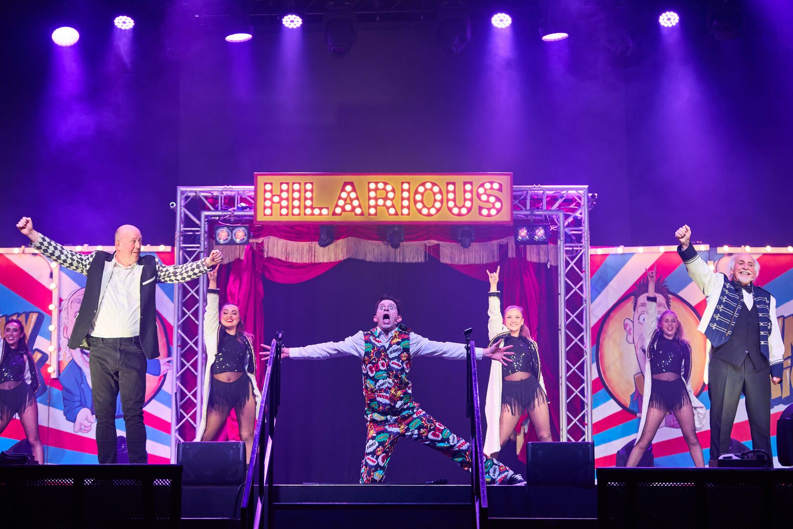 Danny, Mick and Clive Webb all stand together on the stage looking out to the audience.
