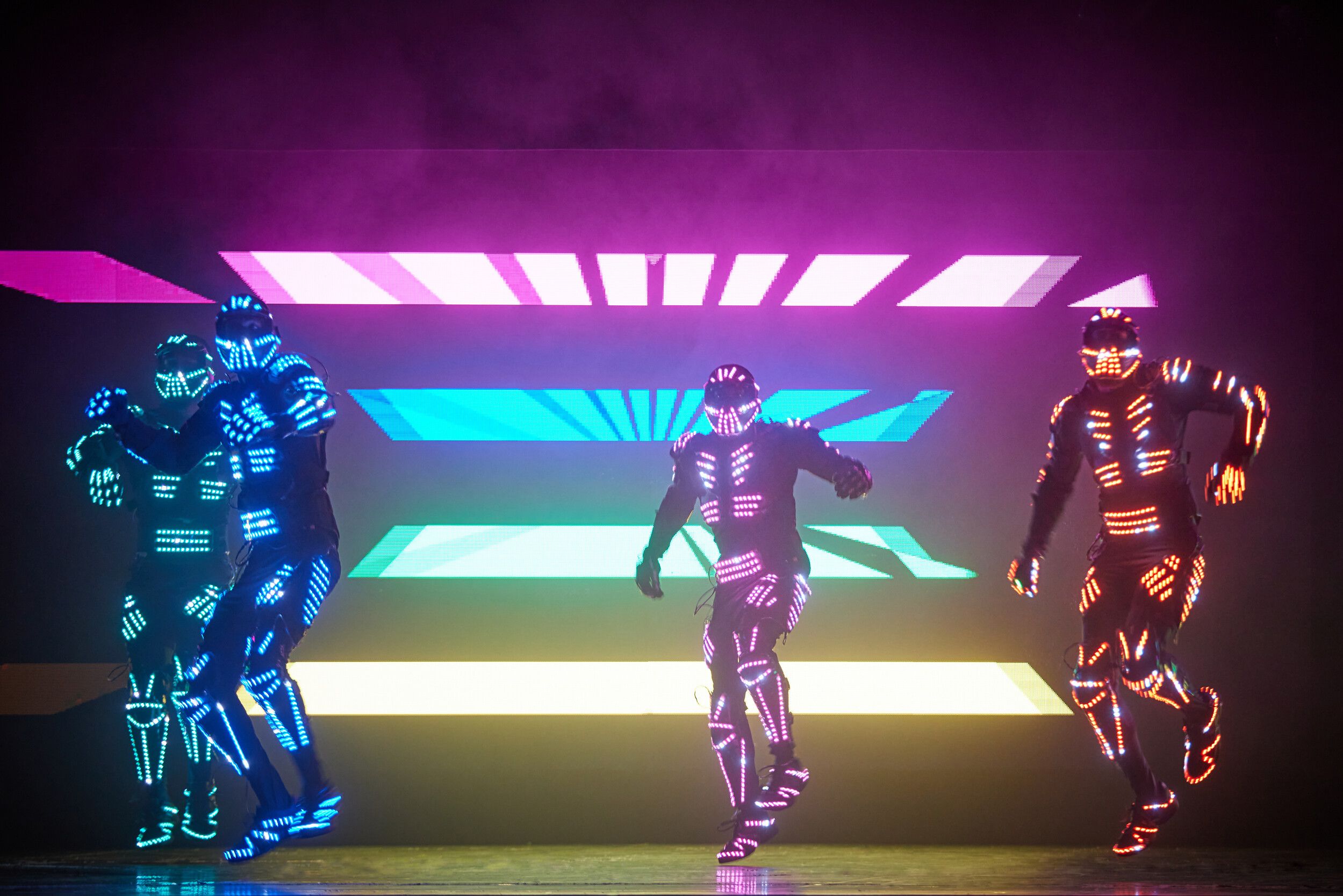 Four members of Electric City performing while wearing LED costumes.