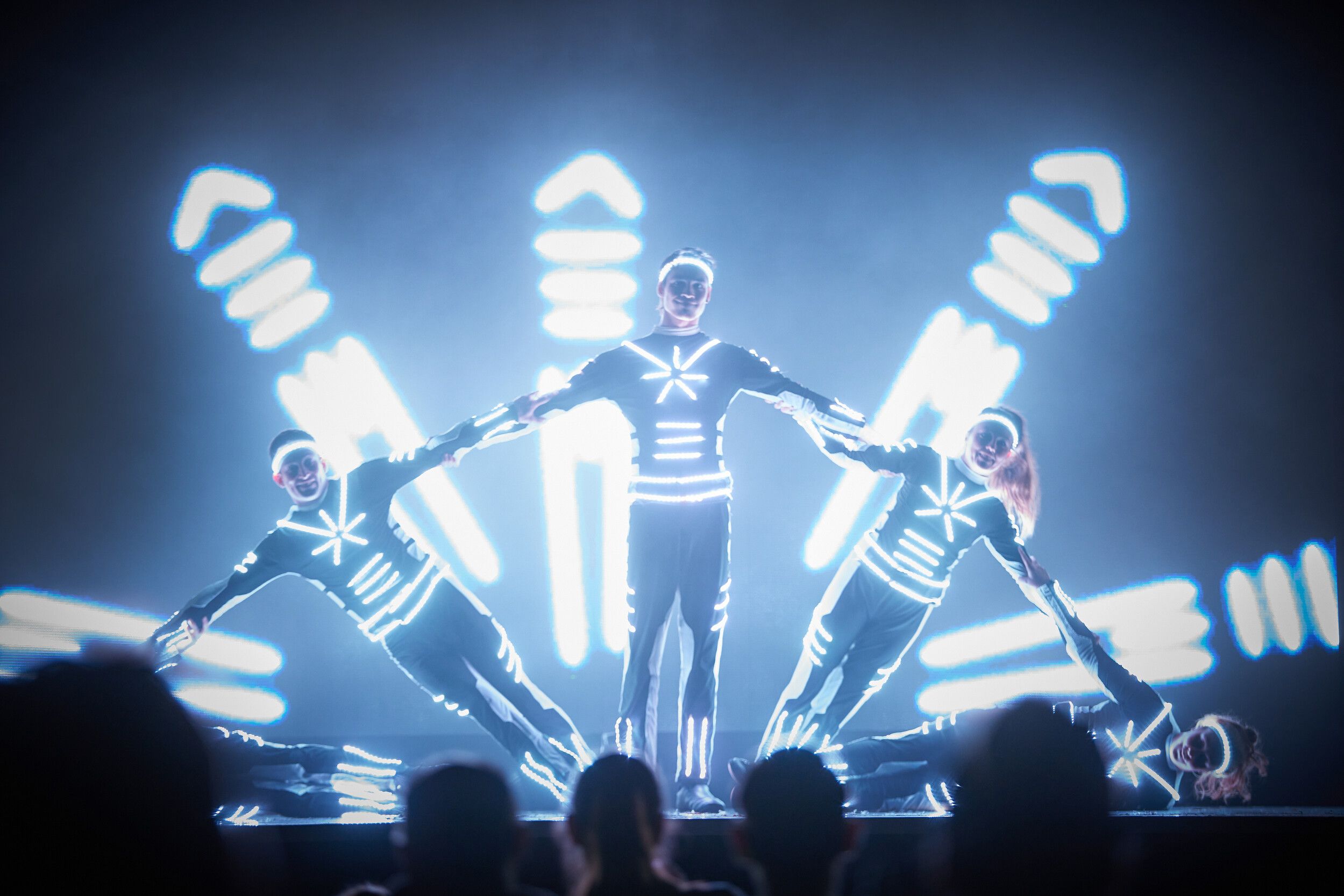 Five members of Electric City performing while wearing LED costumes.