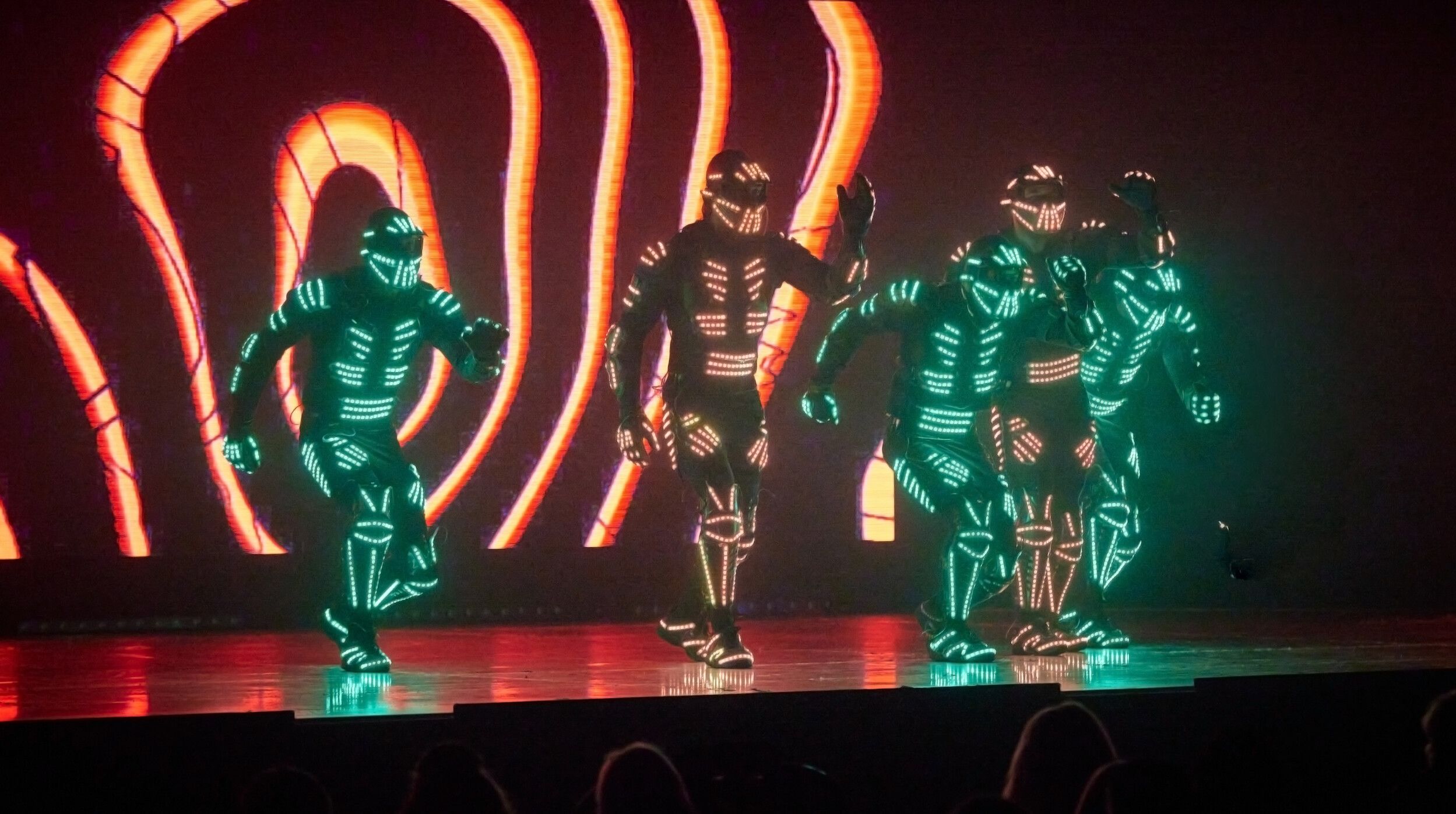Five members of Electric City performing while wearing LED costumes.