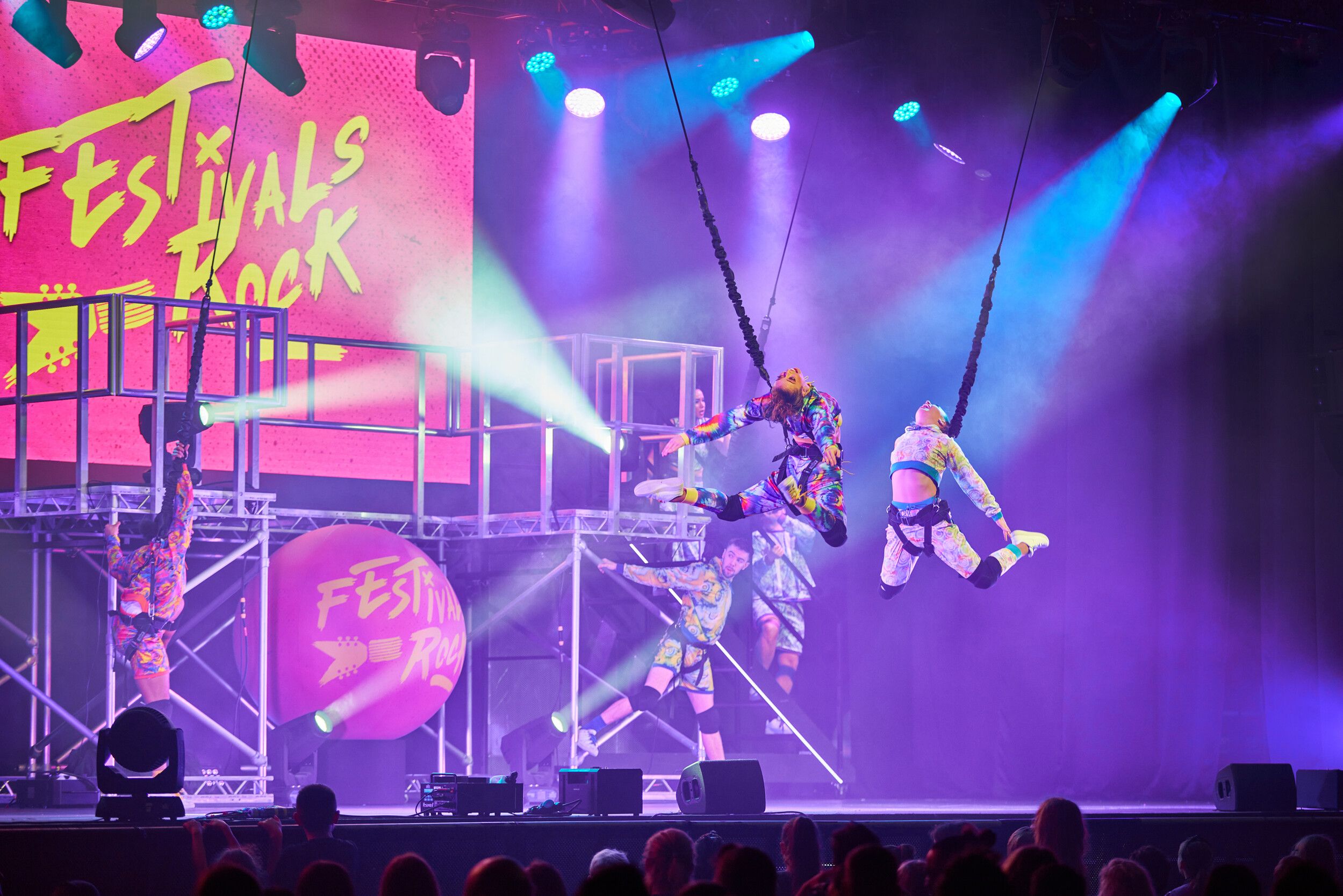 A group of people wearing colourful outfits while performing on stage.