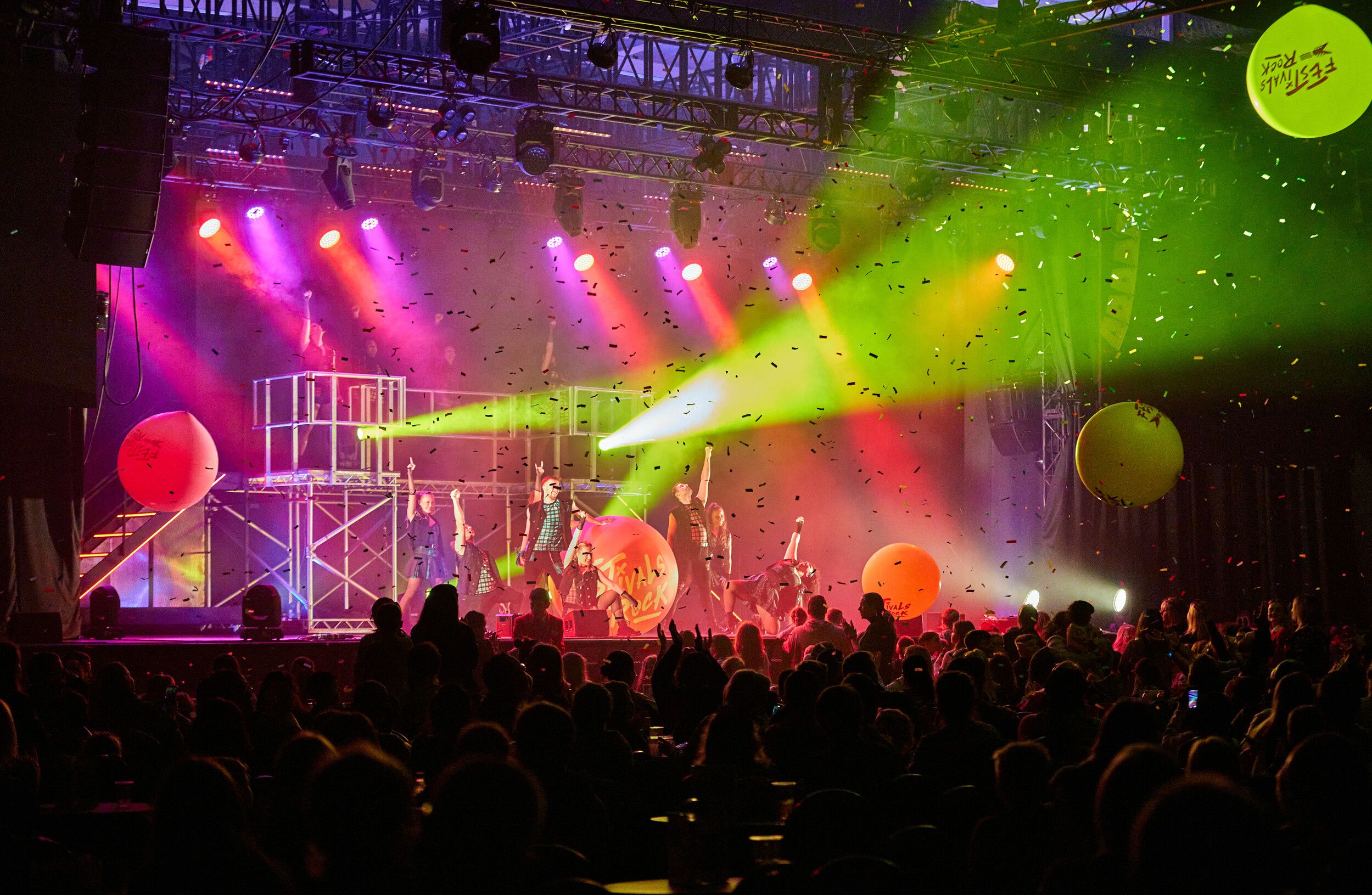 An audience watching a group of people performing on stage.
