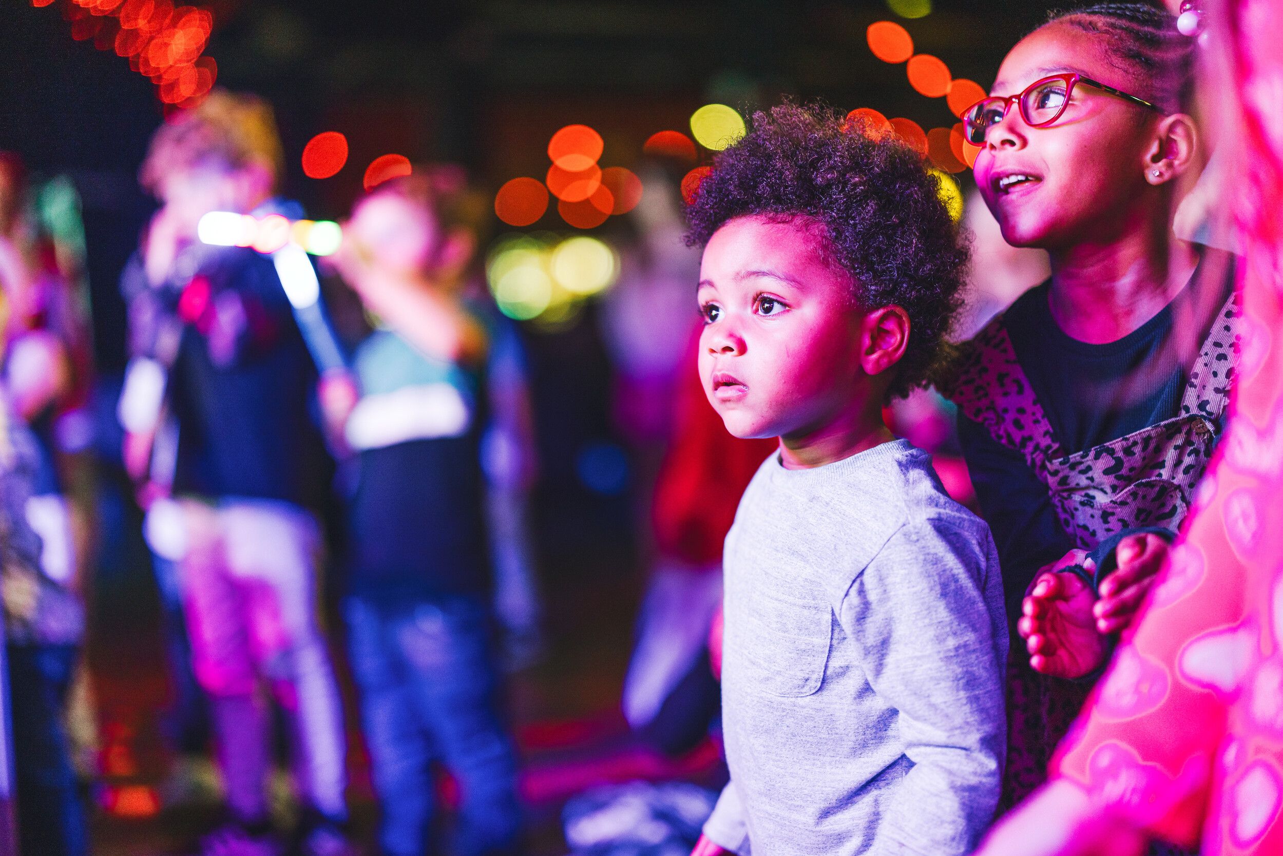 A group of kids at the audience watching an event.