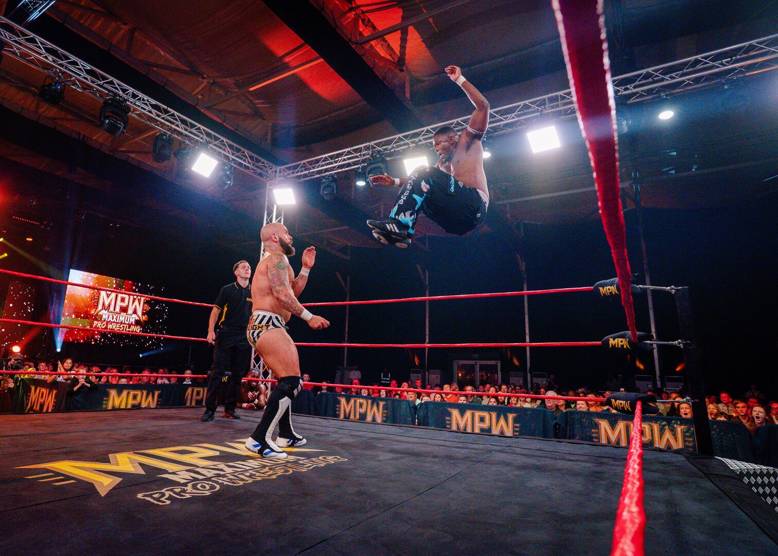 One wrestler jumps down on his opponent in the ring during a Maximum Pro Wrestling show at Butlin's.