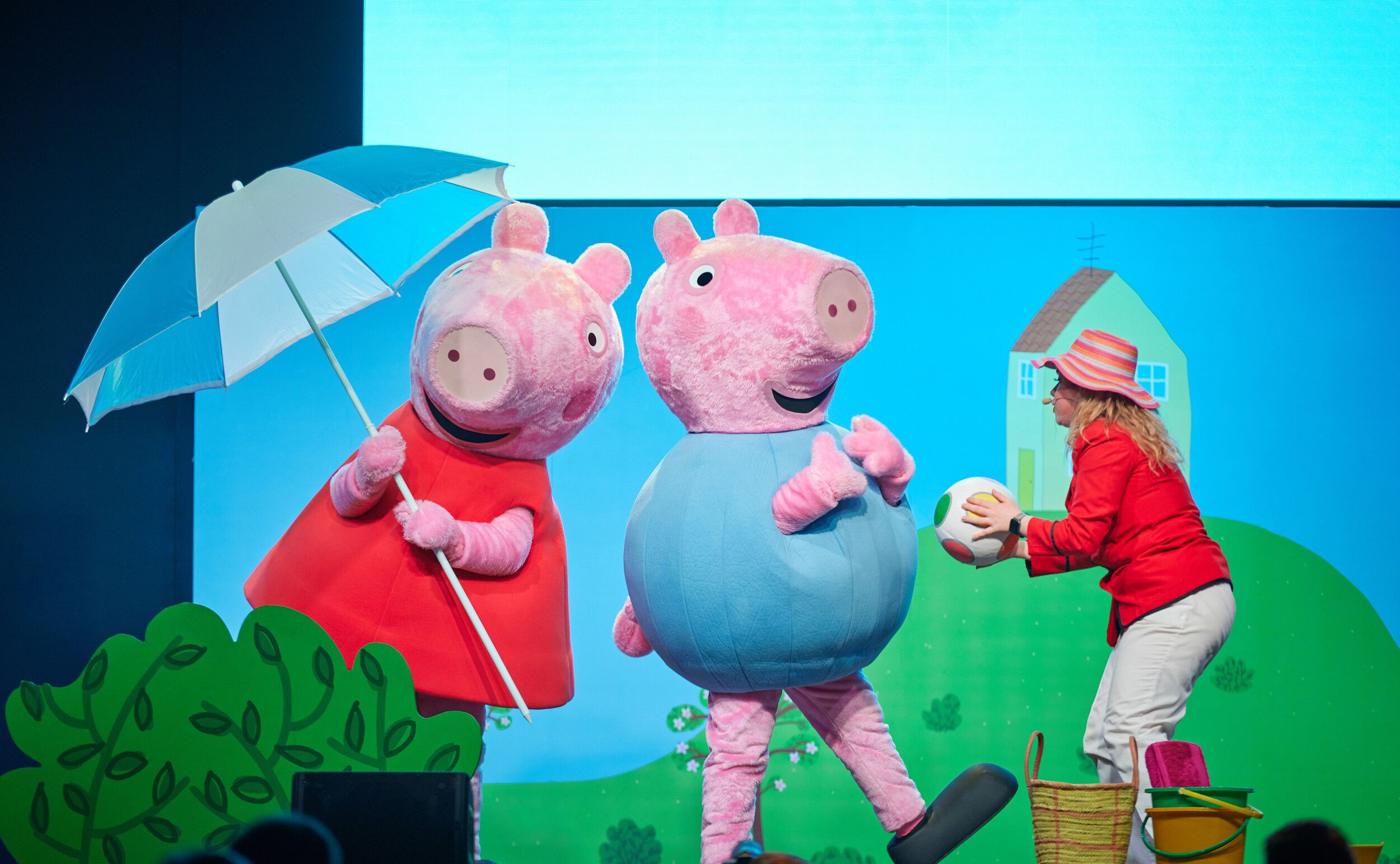 Two Peppa Pig mascots playing and performing on stage.
