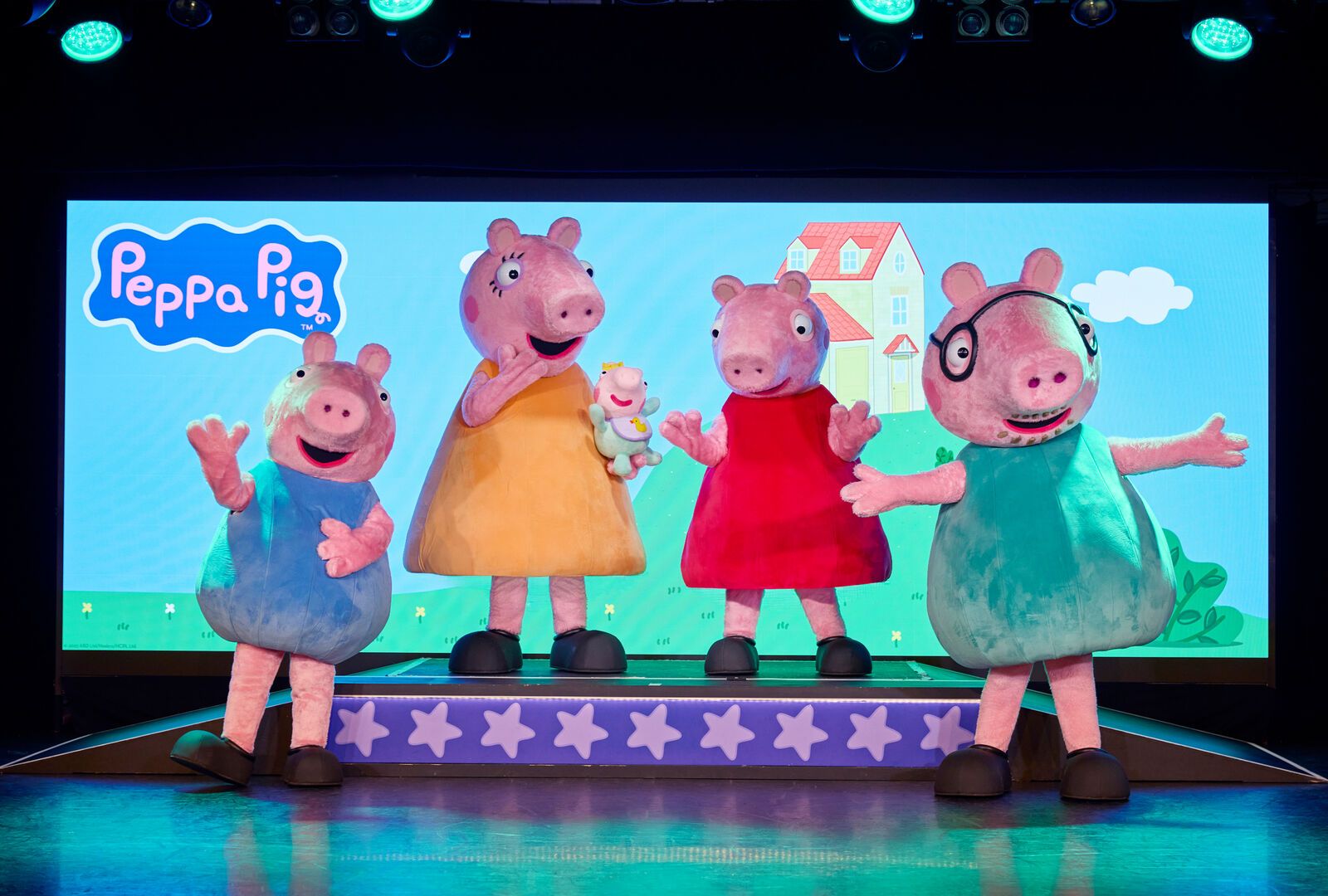 Peppa poses for the camera while on stage with her family (including new baby Evie!)
