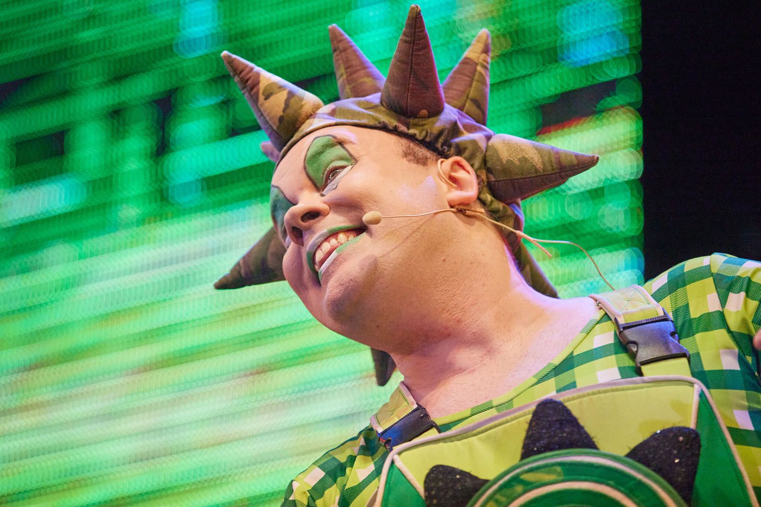 Sprout, a member of Skyline Gang, wearing a green attire while performing on stage.