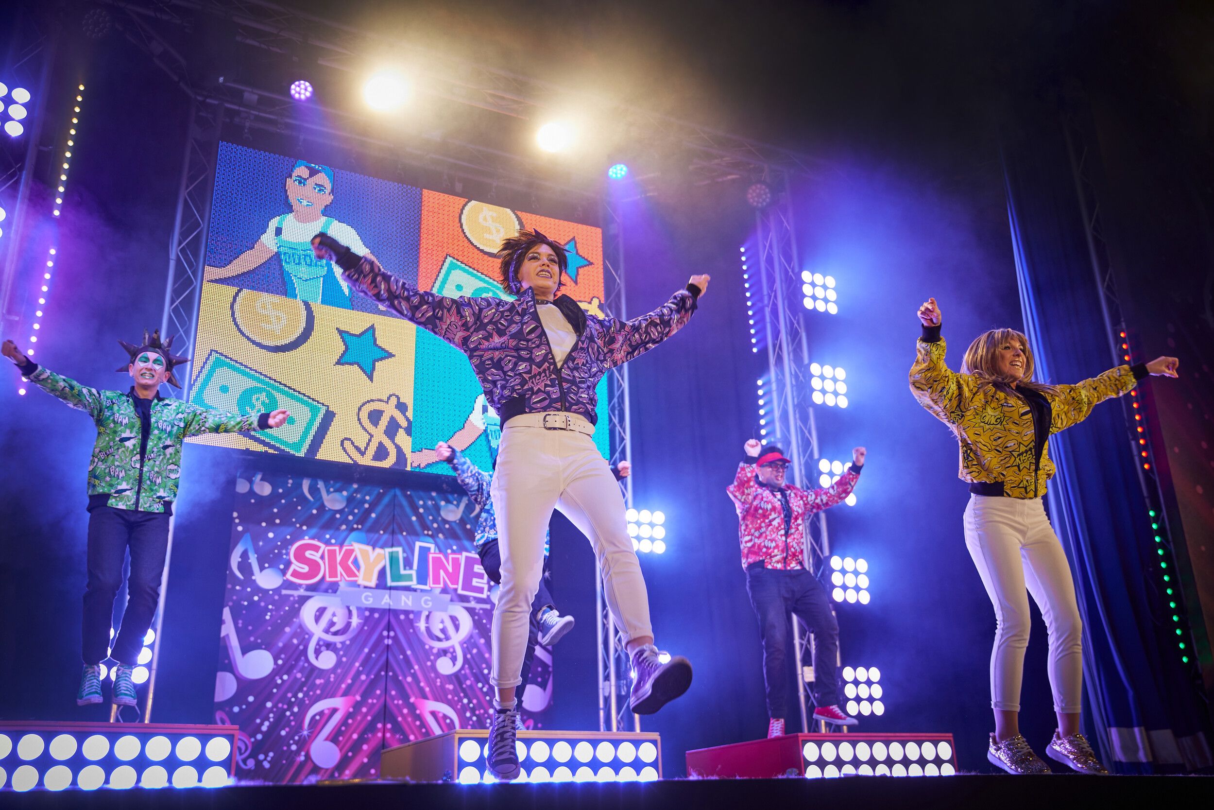Skyline Gang members wearing colourful outfits performing on stage.